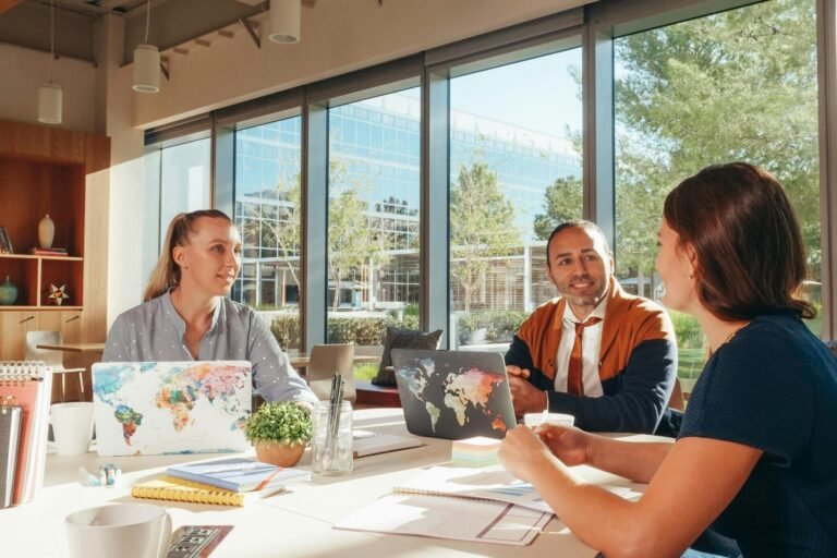 Three diverse professionals collaborate in a bright, modern workspace.